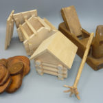 zwei Häuser-Modelle aus Holz, ein Hobel, Baumscheiben