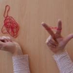 Zwei Hände zeigen, wie man Schmuck auch einfach mit Gummibändern selber machen kann