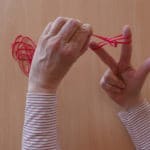 Zwei Hände zeigen, wie man Schmuck auch einfach mit Gummibändern selber machen kann